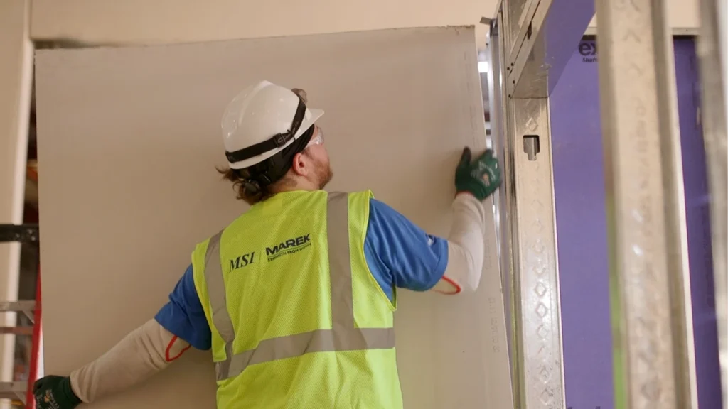 Marek employee hanging drywall